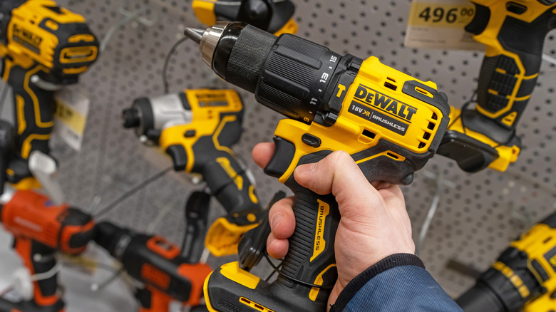 man holding DeWalt drill in hardware store