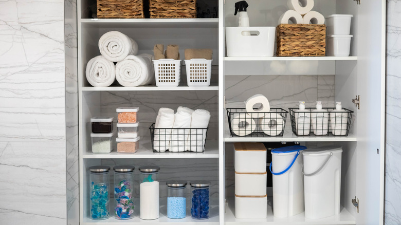 a well organized bathroom cabinet with toilet paper, etc.