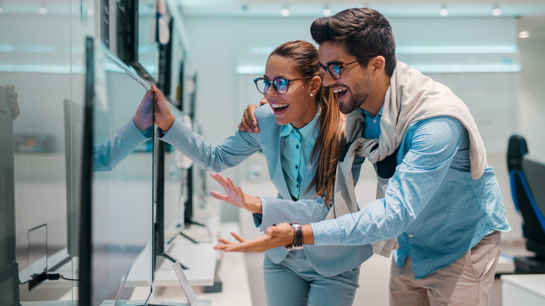 couple shopping for TV in retail store