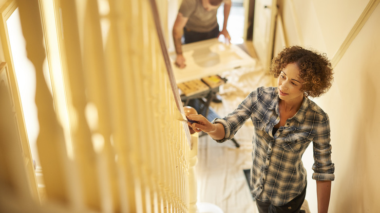 Woman painting staircase railing