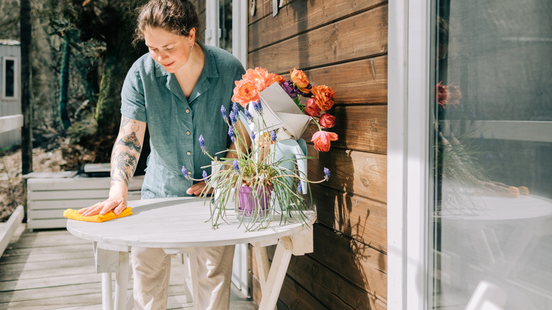 Woman wiping down an outdoor table
