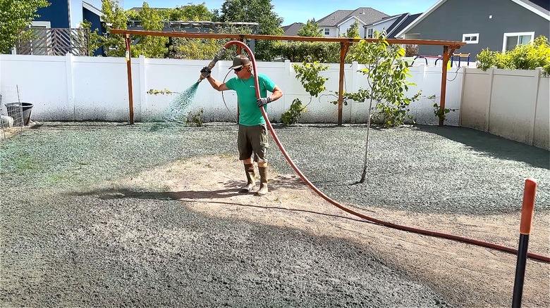 Person hydroseeding backyard space