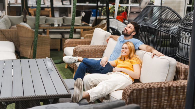 Couple lounging on couch in outdoor furniture section