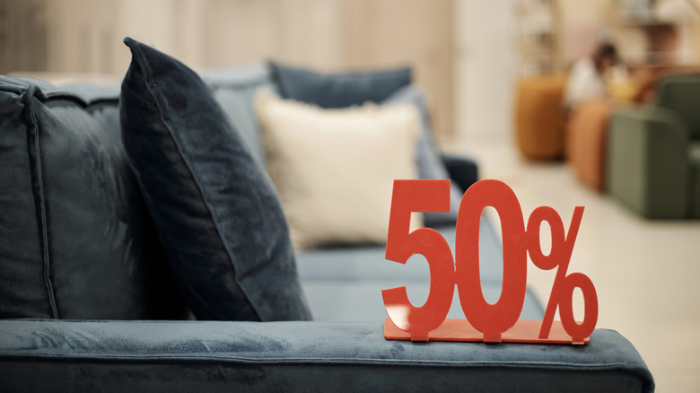A red 50% sign placed on the armrest of a couch