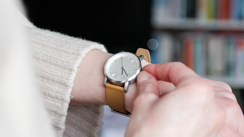 Person setting back their wristwatch
