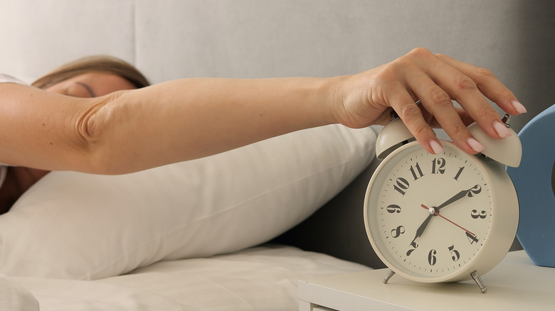 Hand on alarm clock