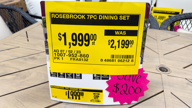 A yellow sale tag on an outdoor dining set at Home Depot