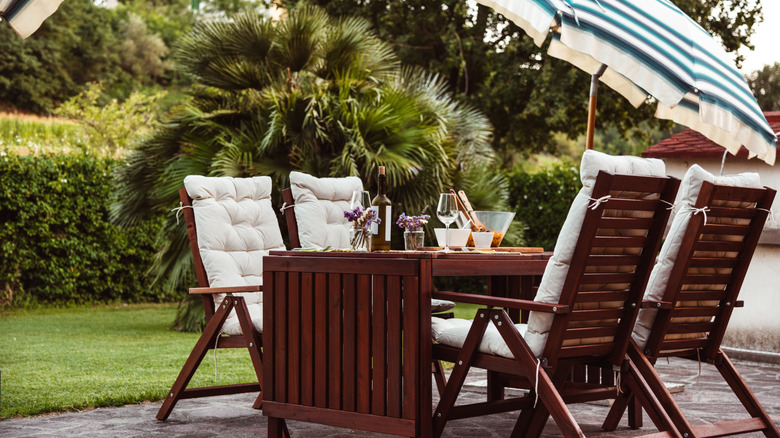 Wooden outdoor furniture with a striped patio umbrella