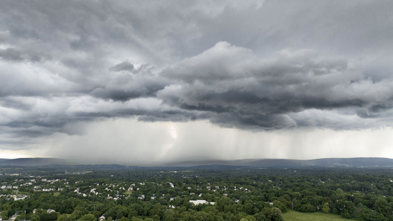 Dark grey rain clouds over green landscape