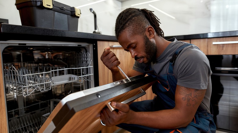 man working on dishwasher