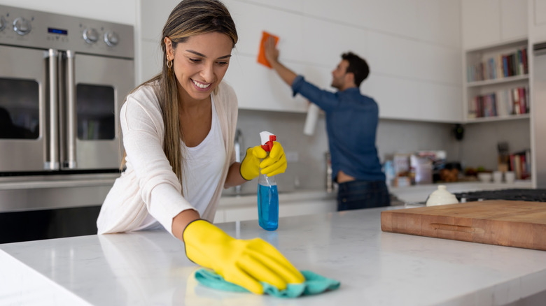 Woman and man cleaning kitchen