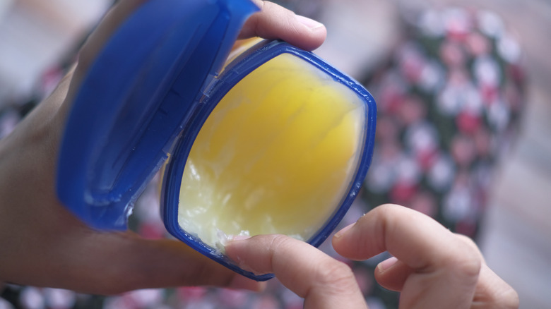 Scooping Vaseline out of a container