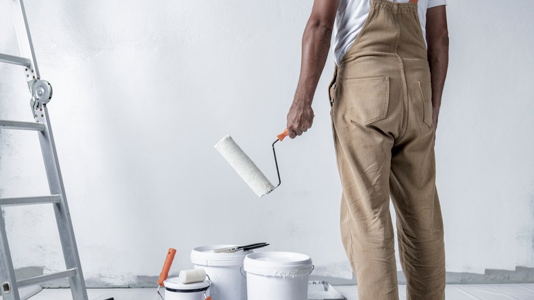 Man holding roller to paint