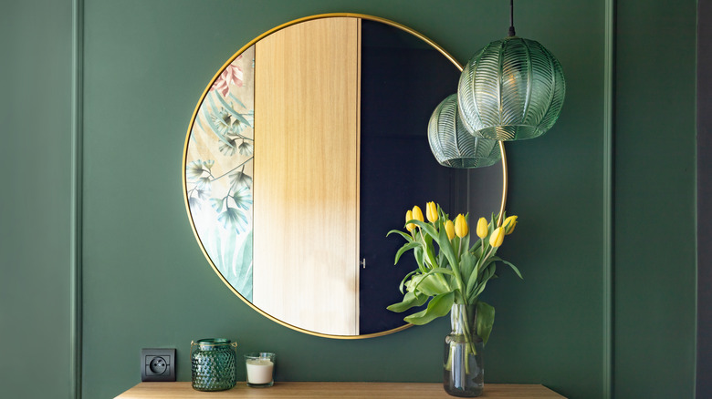 Round mirror green wall