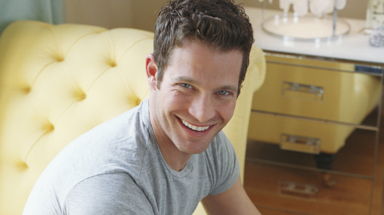 HGTV host and designer Nate Berkus sits on a lemon yellow chaise lounge.