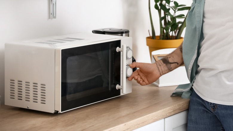 Hand touching microwave dial