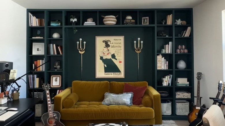 A built-in shelving unit in a den with a sofa in front.