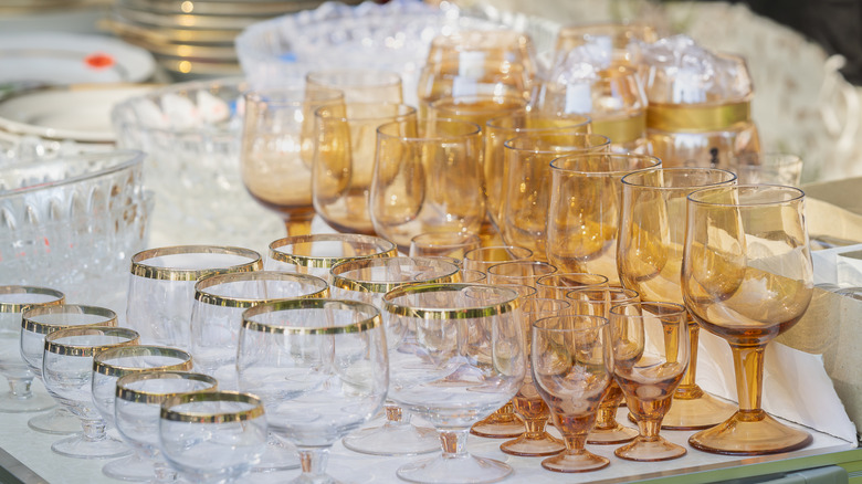 Rows of clear and orange vintage glassware in an antique shop.