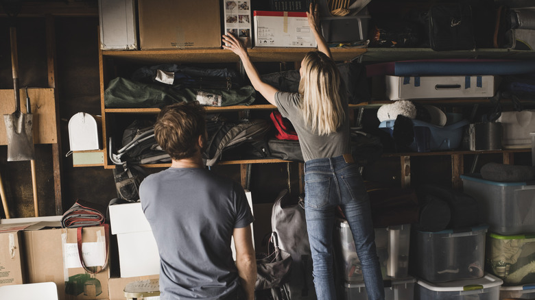 A couple organizing a cluttered garage