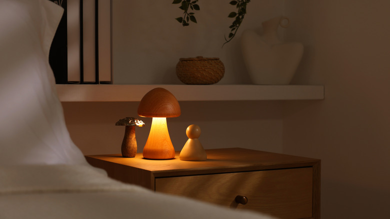 Stylish living room interior with bed, bedside table and night light