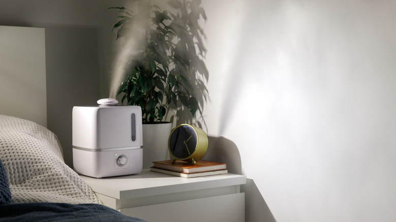 Aroma oil diffuser on the bedside table at night at home