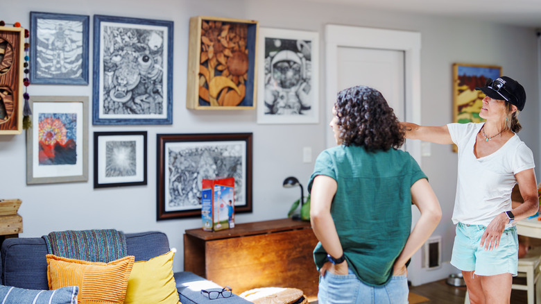 People in a home looking at a gallery wall