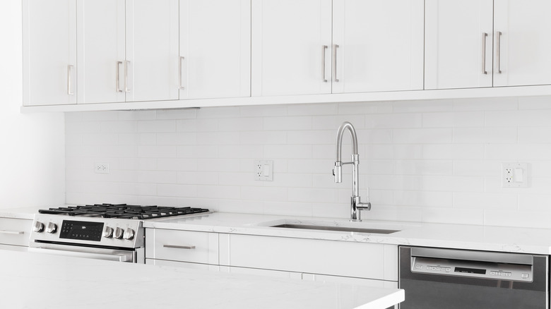 All white kitchen design with white subway tile backsplash