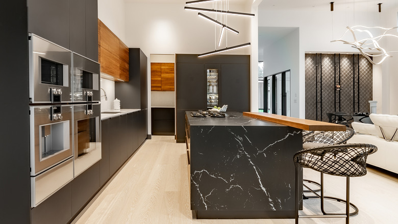 Kitchen with black marble waterfall counter on center island