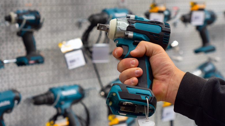 Hand holding a power tool in store