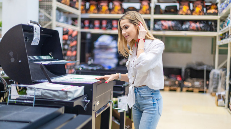 A woman shopping for a grill in a store