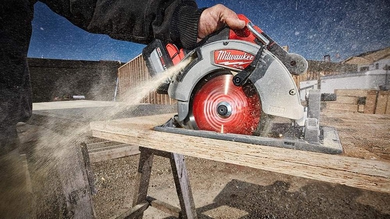 Person using a Milwaukee cordless circular saw