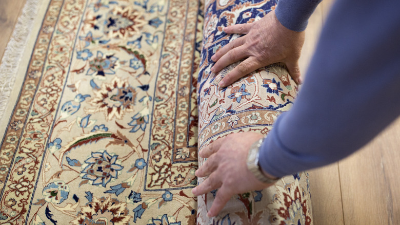 person rolling up rug