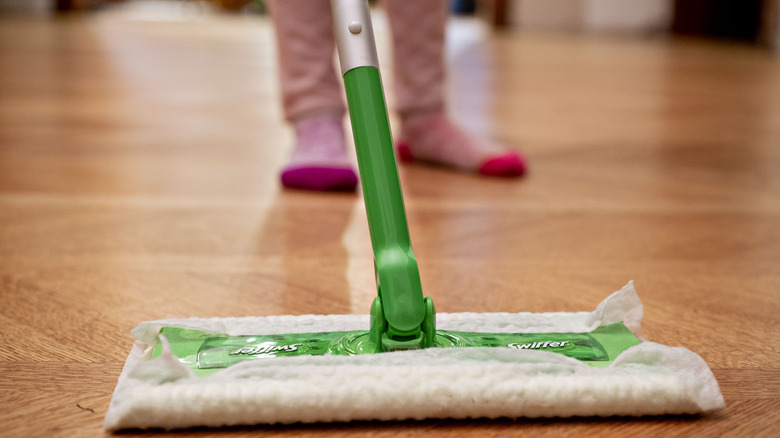 person using Swiffer on hardwood