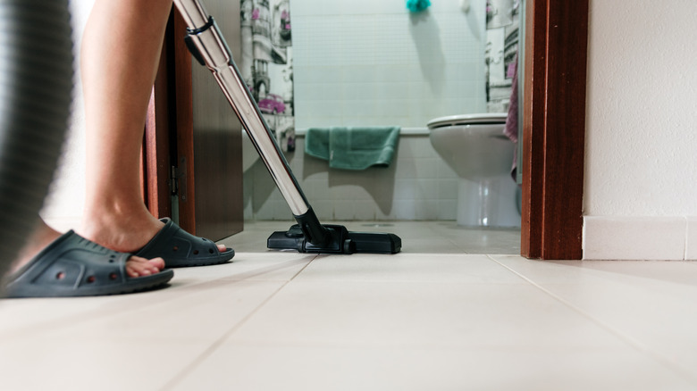 Cleaning the bathroom floor with a vacuum