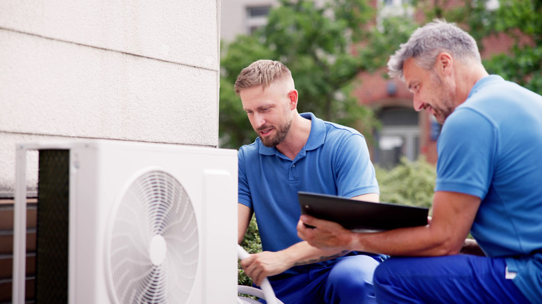 Men inspecting an air conditioner