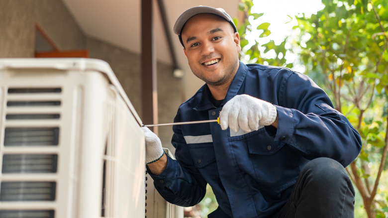 Man working on an outdoor air conditioner unit