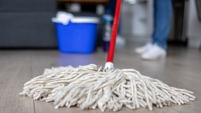 Person mopping with white mop