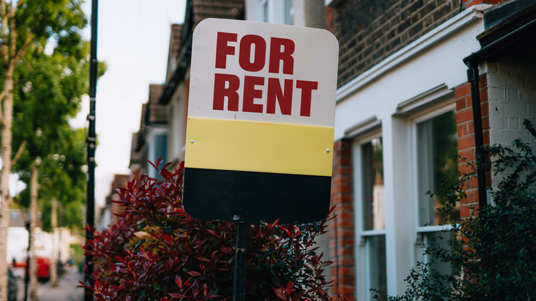 A "for rent" sign in front of a house
