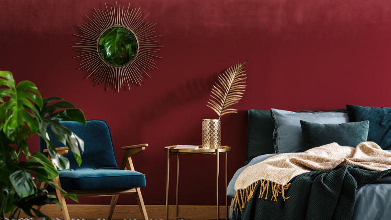 Bedroom with dark red walls and dark blue decor.
