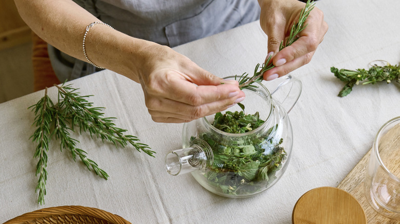 A person making a simmer pot with rosemary