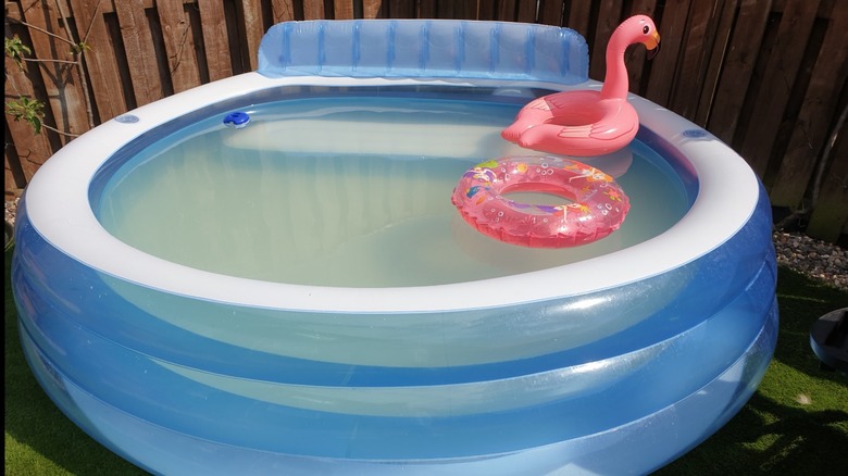 An inflatable pool without a pump and with murky water inside