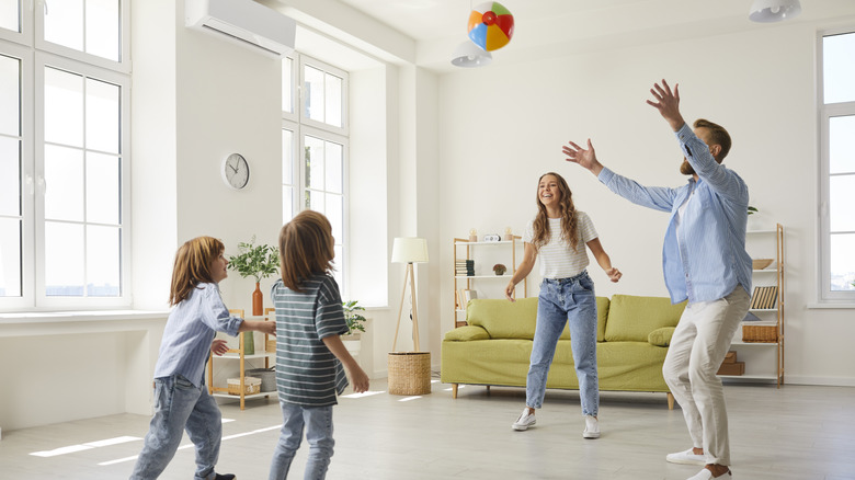 A family playing with a colorful ball in their living room