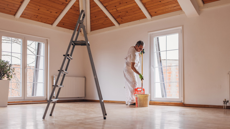Man painting the walls in an open floor plan