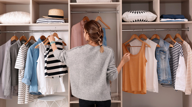 Woman choosing clothes in closet