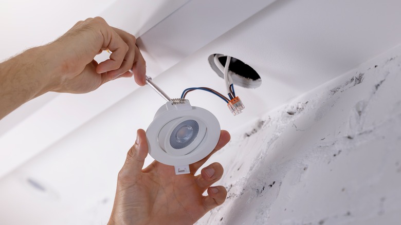 person installing recessed light