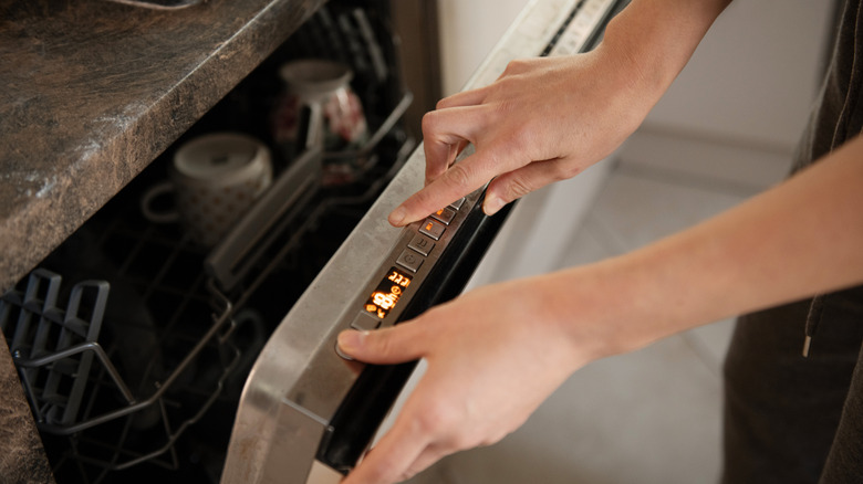 Person adjusting the settings on their dishwasher before running it