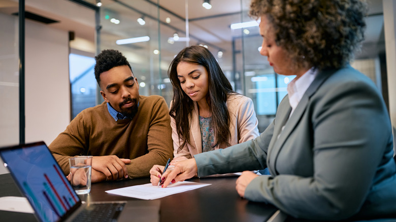 A couple signing mortgage papers for a new home