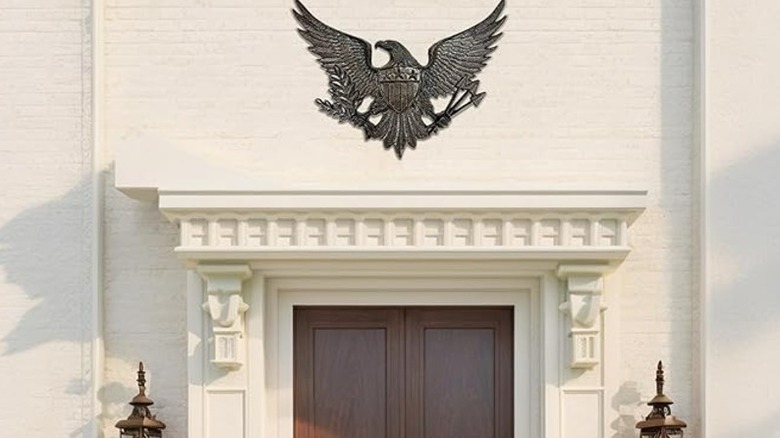 A black eagle plaque at the top of a wood front door