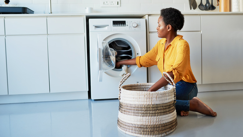 Woman loading washing machine