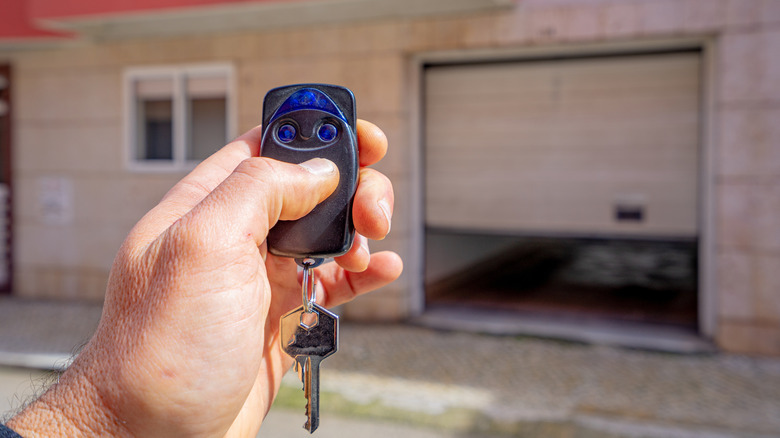 Person closes a garage door part way using a garage door opener remote